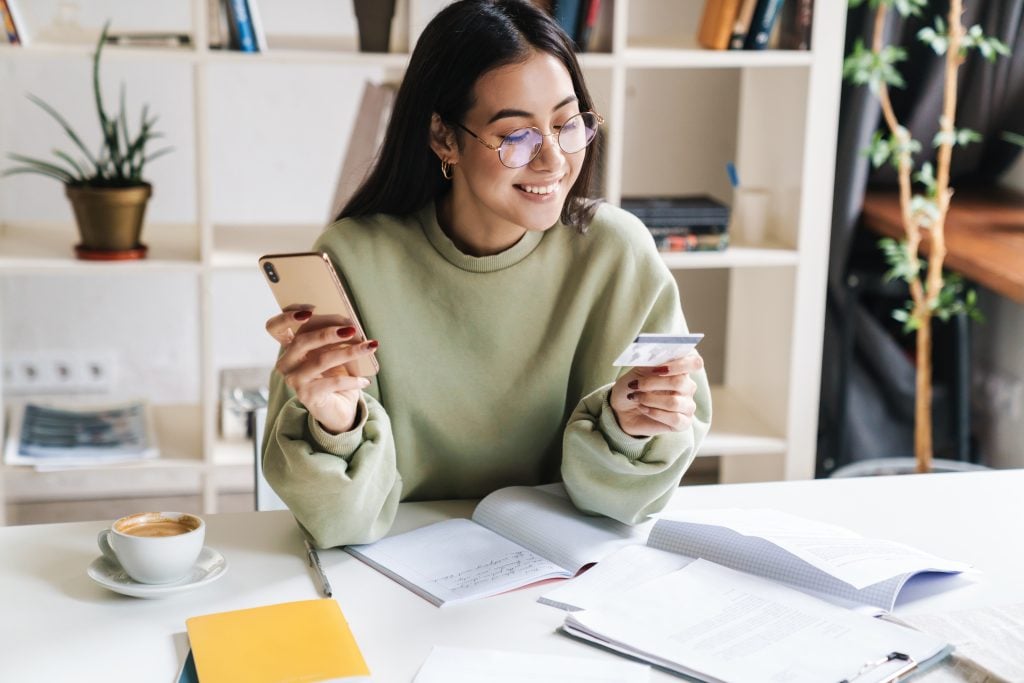 Smiling woman holding a credit card.